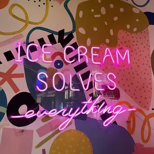 a neon sign that says ice cream solves everything