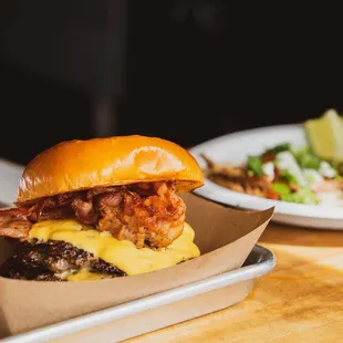 a burger and a salad on a tray