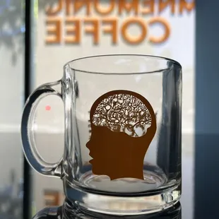 a glass mug with a silhouette of a human head