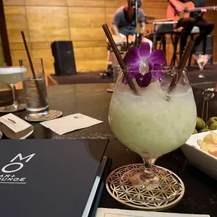 a cocktail with a purple flower garnish