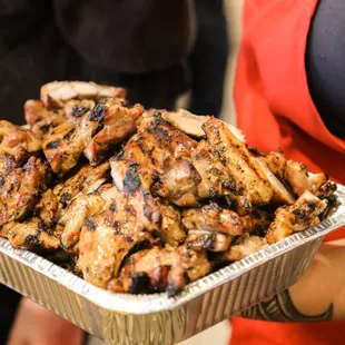  woman holding a tray of chicken