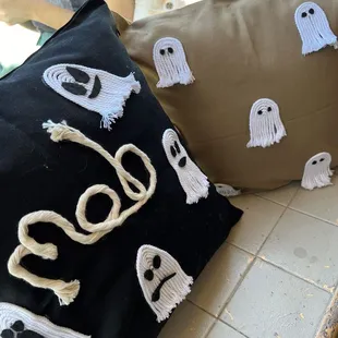 a black pillow with ghost decorations on it