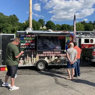  two men standing in front of a food truck