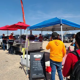 a group of people standing under a tent