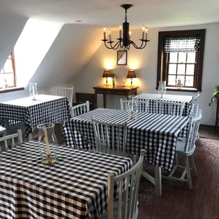 tables and chairs with black and white checkered tablecloths