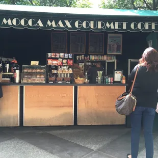a group of people standing in front of a coffee stand