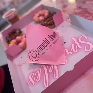 a pink box of doughnuts