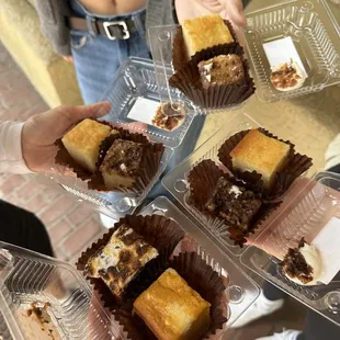 a woman holding a tray of desserts