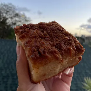 a hand holding a piece of cake