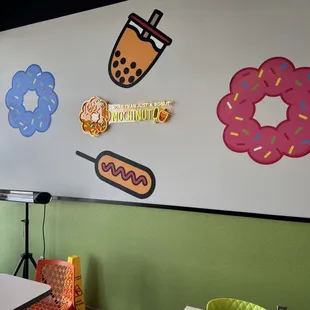 The restaurant features Korean-inspired wall art and board games but is often mistaken for a typical donut shop.