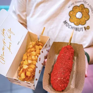 a man holding two boxes of food