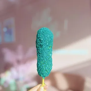 a hand holding a blue mochi ice cream