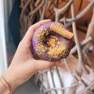 a hand holding a purple donut