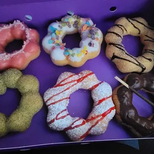 a variety of doughnuts in a purple box