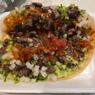 Sirloin quesadilla with homemade flour tortillas and guacamole and onions.