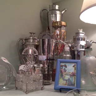 Huge assortment of silver vintage martini shakers and bar ware .