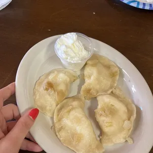 Mashed potato and cheese pierogis with sour cream