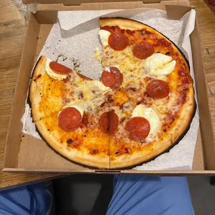 a half eaten pepperoni pizza in a box