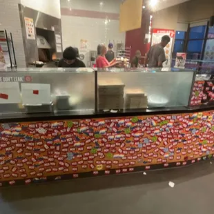 Manager with hair down and not gloved touching pizzas.