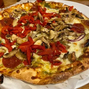 Pizza: roasted tomatoes, bell peppers, mushrooms, whole and minced garlic, pepperoni, red onions  with pesto and olive oil topping.