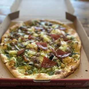 Custom pizza w/pesto, garlic, fresh basil, mozarella, ricotta, roasted garlic, mushrooms, red onion, pineapple, salami, italian sausage ~