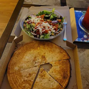 a pizza in a box and a salad in a bowl