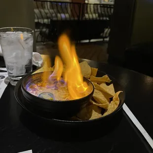 a bowl of nachos with flames
