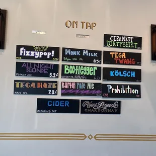 a variety of beer signs on a wall