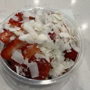 Acai bowl with strawberries, coconut flakes, and granola.