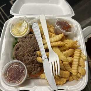 Burger on a bed of lettuce, onion, tomato, &amp; pickle with french fries