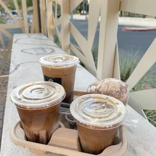 three cups of iced coffee on a tray