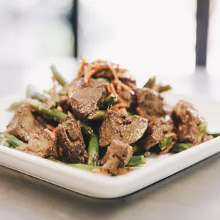 a plate of beef and green beans