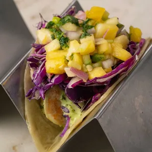 a fish taco with pineapple salsa