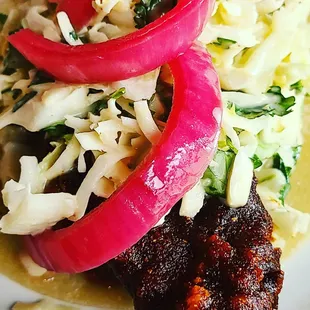 a taco with onions and coleslaw