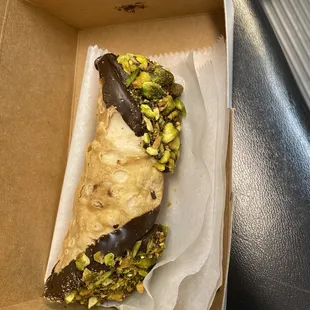 Chocolate dipped cannoli with chocolate filling and pistachios