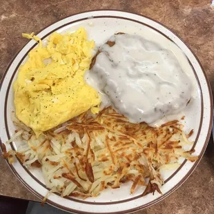 a plate of eggs, hash browns and gravy