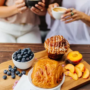 two women holding cups of coffee and pastries