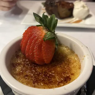 a bowl of creme with a strawberry on top