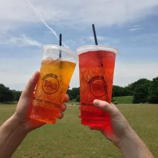 two people holding drinks