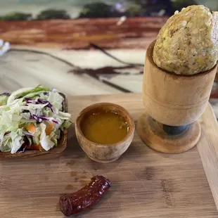 a sandwich, coleslaw, and hot sauce