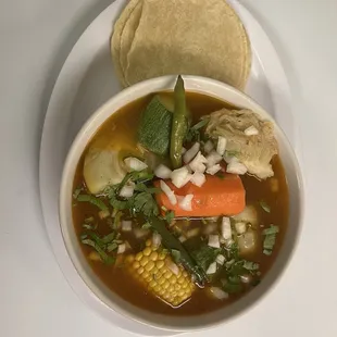  a bowl of soup and a tortilla