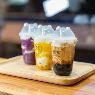 three iced drinks on a wooden tray