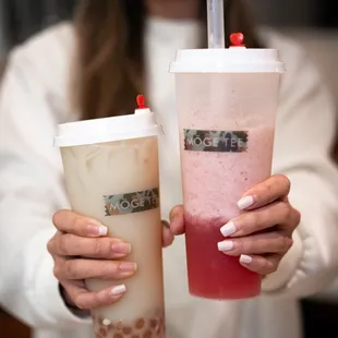 a woman holding two drinks