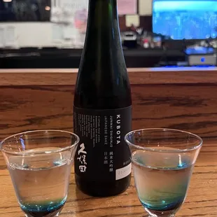 a bottle and two glasses on a table