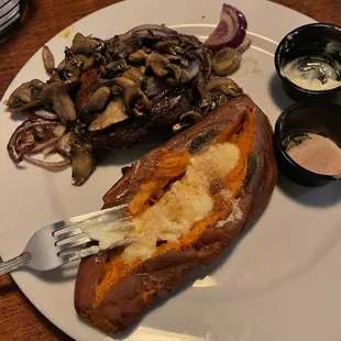 Skirt steak topped with mushrooms and onions with a sweet potato