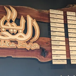 a wooden sign with arabic calligraphy