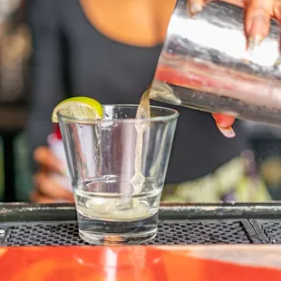 a bartender pouring a drink at a bar