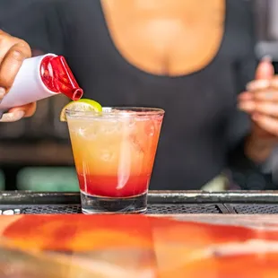 a bartender pouring a drink at a bar