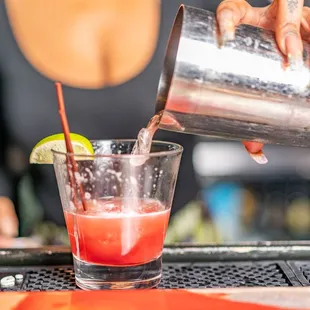 a bartender pouring a drink at a bar