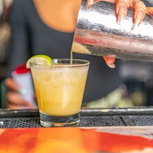 a bartender pouring a drink at a bar
